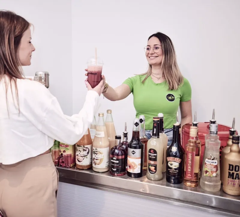 Barkeeperin reicht einen frisch gemixten Cocktail beim Cocktailkurs